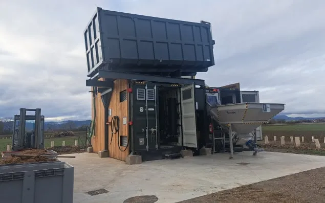 The BioCapsule unit with its access doors open, showing the wood-clad enclosure